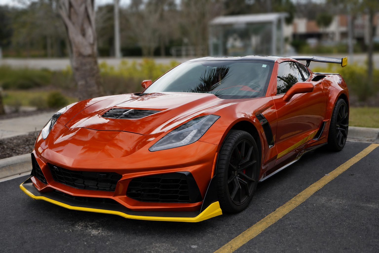Orange Corvette with yellow aero accents against a softly blurred background
