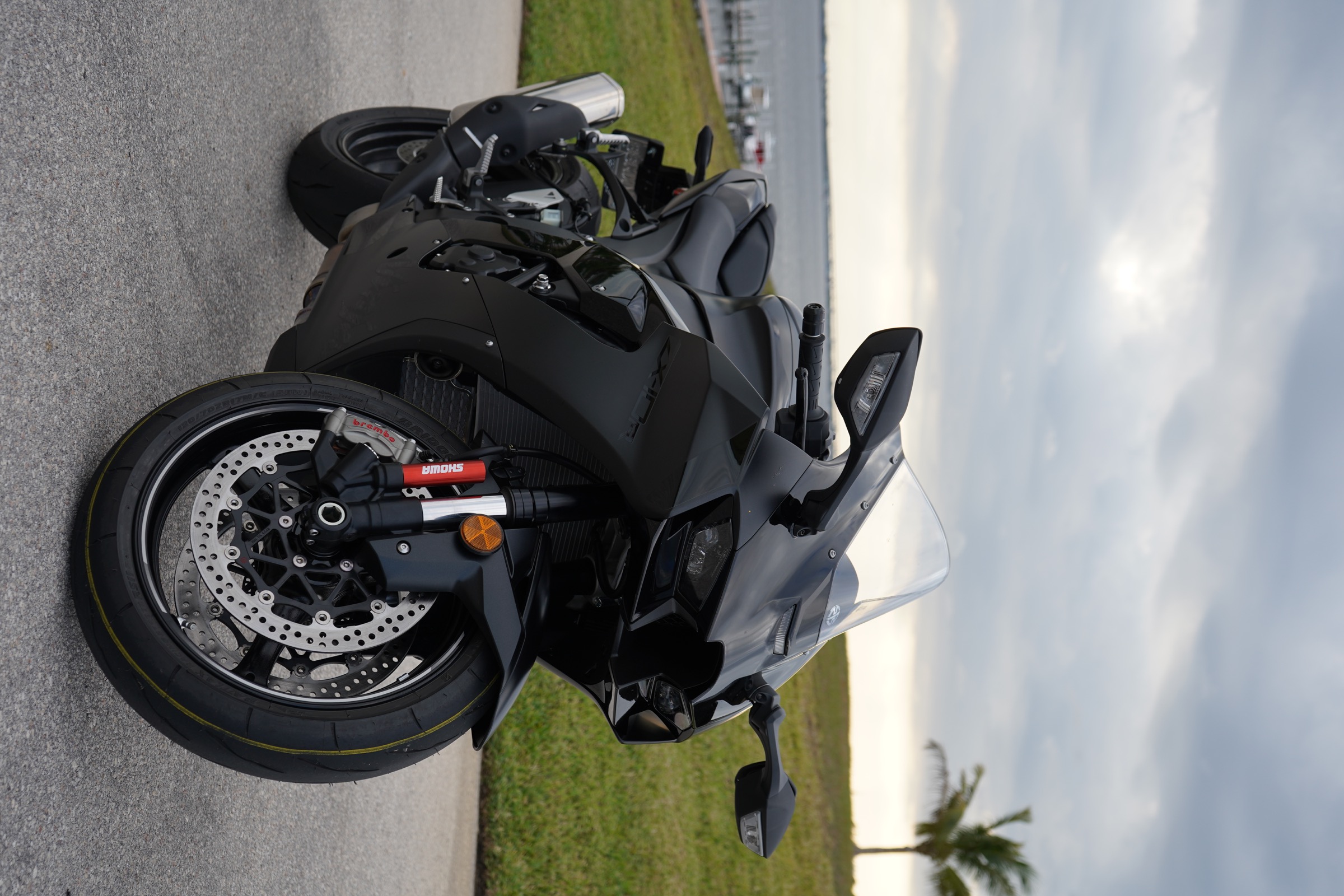 Matte black sport motorcycle beside the water