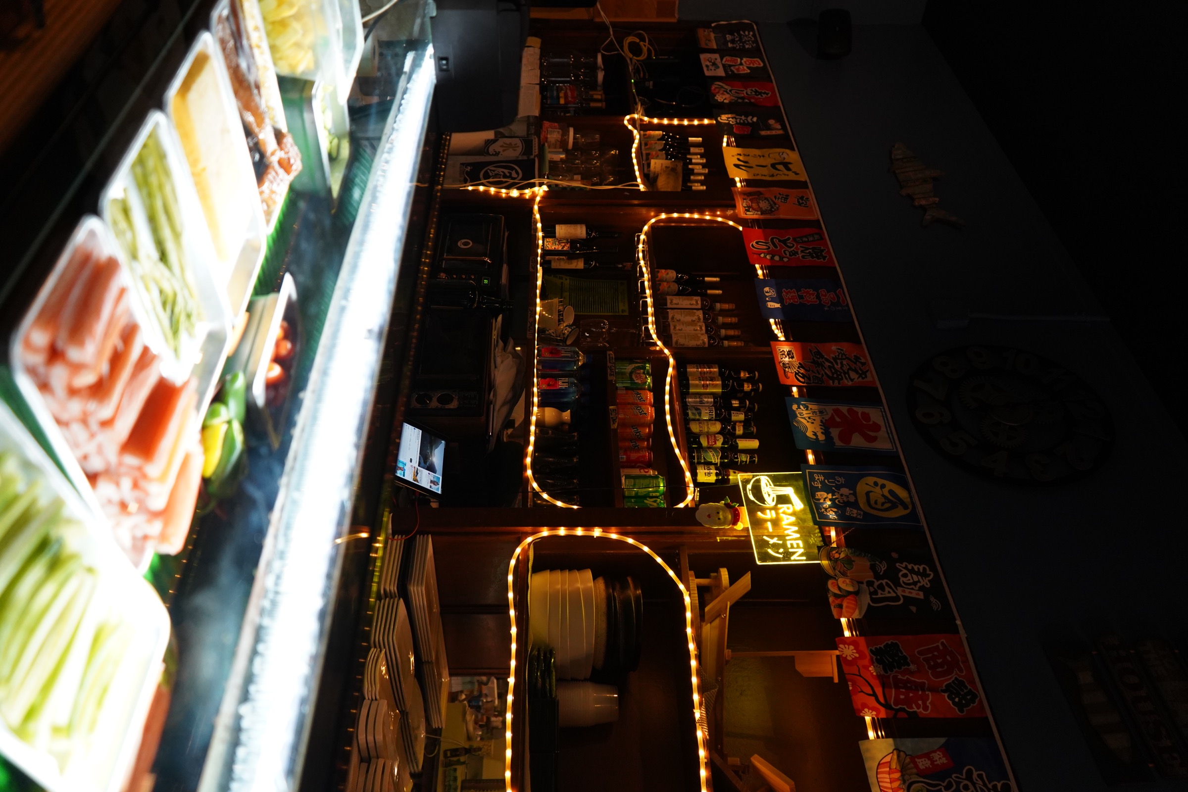 Warmly lit ramen bar with a neon sign